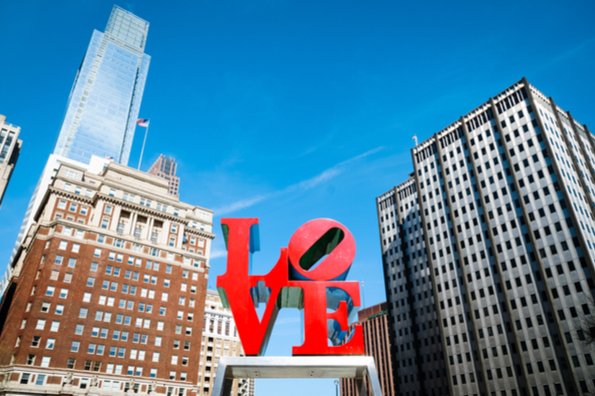 The Philadelphia Love scultpure with a few buildings in the background.