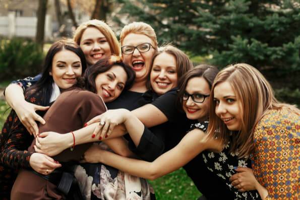 A group of friends smiling and embracing each other.